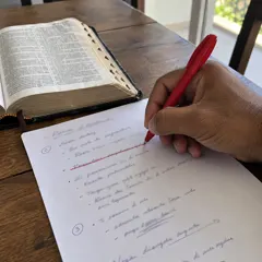 Mão riscando uma linha da folha da pregação com caneta vermelha