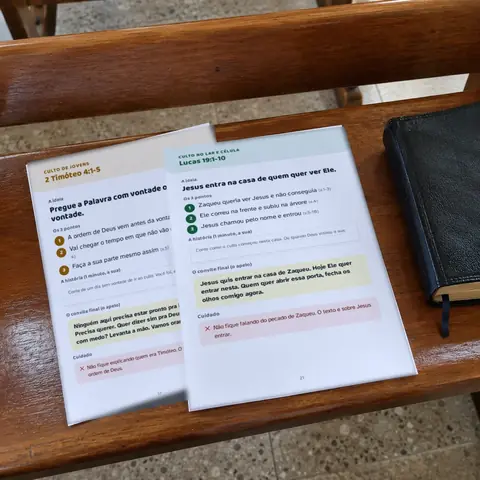 Dois esboços impressos, de culto de jovens e de célula, sobre o banco da igreja
